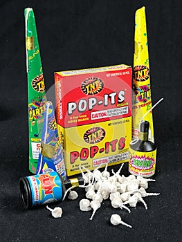 Low Grade hand held fireworks like Pop Its and Party Poppers on a black backdrop