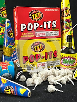 Low Grade hand held fireworks like Pop Its and Party Poppers on a black backdrop