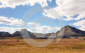 Low grass growing on African savanna, small rocky mountains in background - typical scenery at Isalo national Park