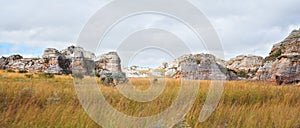 Low grass growing on African savanna, small rocky mountains in background - typical scenery at Isalo national Park, Madagascar