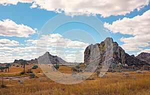 Low grass growing on African savanna, small rocky mountains in background - typical scenery at Isalo national Park, Madagascar