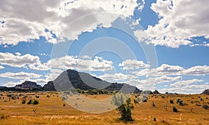 Low grass growing on African savanna, small rocky mountains in background - typical scenery at Isalo national Park, Madagascar