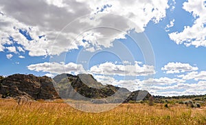 Low grass growing on African savanna, small rocky mountains in background - typical scenery at Isalo national Park, Madagascar