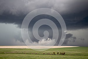 A low hanging wall cloud almost touches the ground under a supercell thunderstorm.