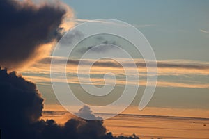 Low and high clouds in blue sky at sunset