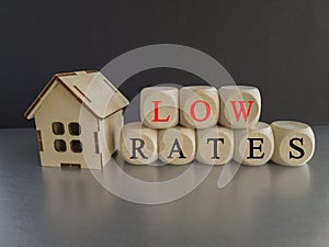 Low house rates symbol. Concept red words 'Low rates' on wooden cubes near miniature houses.