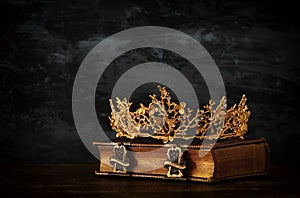 low key image of beautiful queen/king crown on old book. vintage filtered. fantasy medieval period.