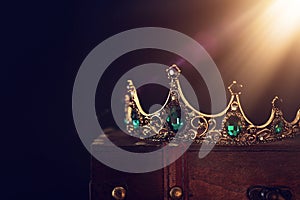 low key image of beautiful queen/king crown over wooden table. vintage filtered. fantasy medieval period