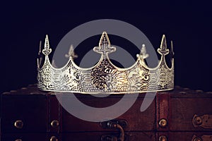 low key image of beautiful queen/king crown over wooden table. vintage filtered. fantasy medieval period