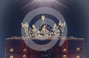 low key image of beautiful queen/king crown over wooden table. vintage filtered. fantasy medieval period