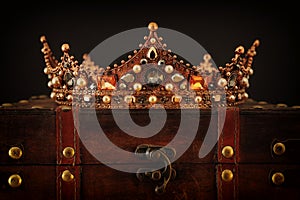 low key image of beautiful queen/king crown over wooden table. vintage filtered. fantasy medieval period