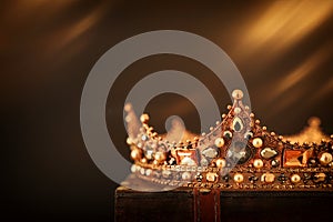 low key image of beautiful queen/king crown over wooden table. vintage filtered. fantasy medieval period