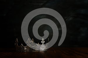 Low key image of beautiful queen/king crown over wooden table. vintage filtered. fantasy medieval period