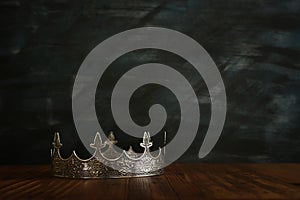 Low key image of beautiful queen/king crown over wooden table. vintage filtered. fantasy medieval period