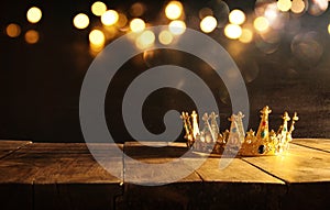 low key of queen/king crown over wooden table. vintage filtered. fantasy medieval period photo