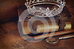 Low key image of diamond queen crown on old book