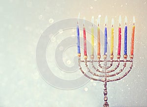 Low key image of jewish holiday Hanukkah background with menorah Burning candles over glitter background