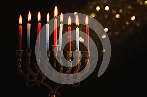 Low key Image of jewish holiday Hanukkah background with menorah & x28;traditional candelabra& x29; and burning candles.