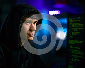 Low Key Lighting Shot Of Male Computer Hacker Sitting In Front Of Screens Breaching Cyber Security