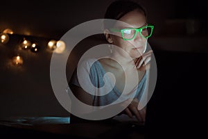 Low key portrait of woman working on laptop at night