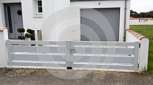 Low modern steel metal gate white of home suburb street access house garden