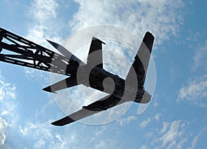 Old military plane monument on blue sky background