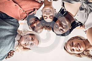 Low portrait of a group of five joyful diverse businesspeople standing together in an office at work. Faces of business
