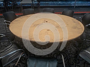 Low-quality wooden round tables present in the black and silver hall of the Estoril casino.