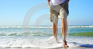 Low section of active senior man walking on the beach 4k