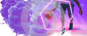 Low section of biracial basketball player dribbling ball by illuminated hexagon on smoky background