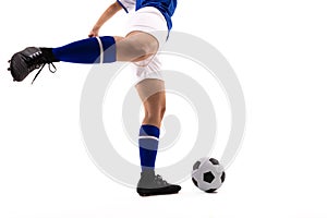 Low section of biracial female soccer player kicking soccer ball against white background