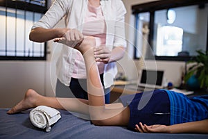 Low section of boy receiving foot massage from young female therapist