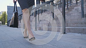 Low section of business woman walking to job