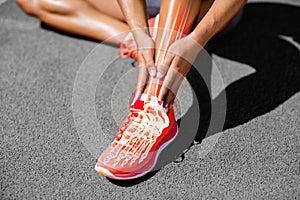 Low section of female athlete suffering from joint pain on track photo