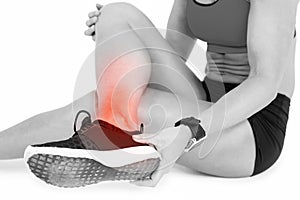 Low section of female sportsperson suffering from ankle pain on white background
