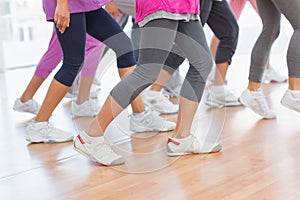 Low section of fitness class doing pilates exercise