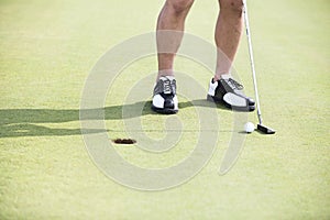 Low section of man with golf club and ball