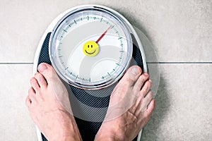 Low section of man standing on weight scale