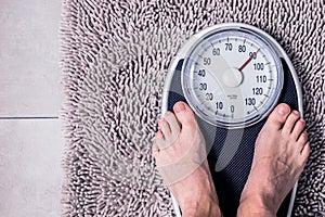 Low section of man standing on weight scale