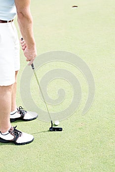 Low section of mid-adult man playing golf