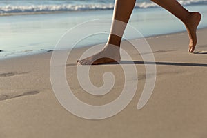 Low section of mixed race woman on beach practicing yoga durning sunset