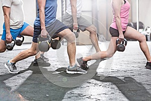 Low section of people lifting kettlebells at crossfit gym