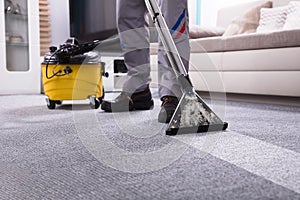 Person Cleaning Carpet With Vacuum Cleaner