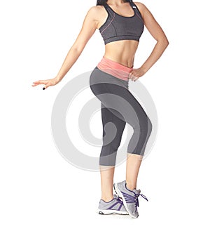 Low section of sportive woman standing on a white background