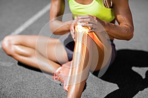 Low section of sportswoman suffering from knee pain