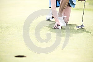 Low section of woman placing ball at golf course