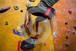 Low section of woman practicing rock climbing