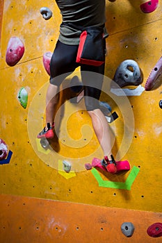 Low section of woman practicing rock climbing