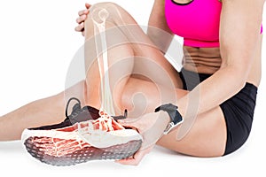 Low section of woman suffering from ankle pain on white background