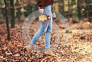 Low section of woman walking in autumn forest